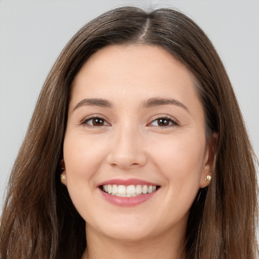 Joyful white young-adult female with long  brown hair and brown eyes