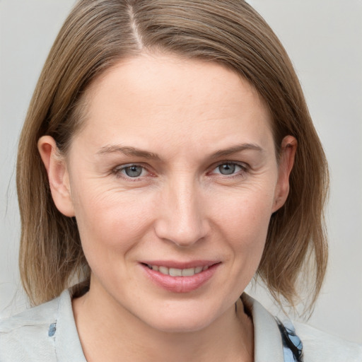 Joyful white young-adult female with medium  brown hair and grey eyes