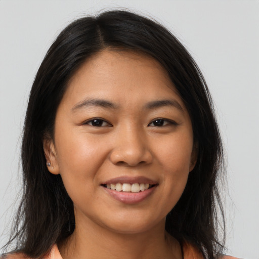 Joyful latino young-adult female with long  brown hair and brown eyes