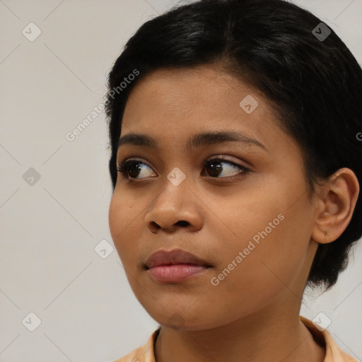 Joyful black young-adult female with medium  black hair and brown eyes