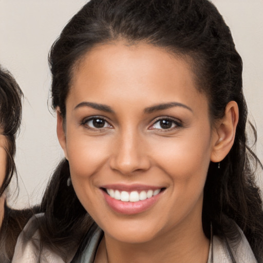 Joyful white young-adult female with long  brown hair and brown eyes