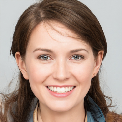 Joyful white young-adult female with medium  brown hair and grey eyes