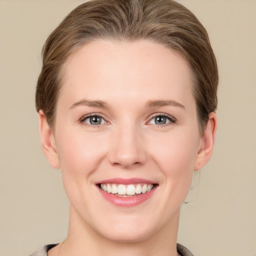 Joyful white young-adult female with short  brown hair and grey eyes