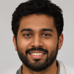 Joyful latino young-adult male with short  black hair and brown eyes