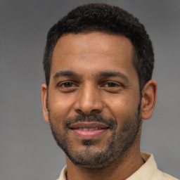Joyful latino young-adult male with short  black hair and brown eyes