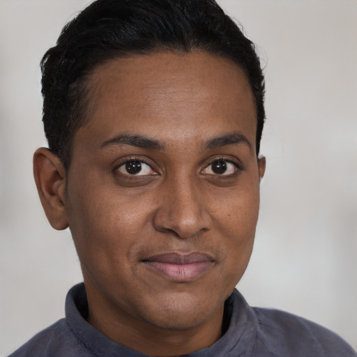 Joyful black young-adult male with short  brown hair and brown eyes