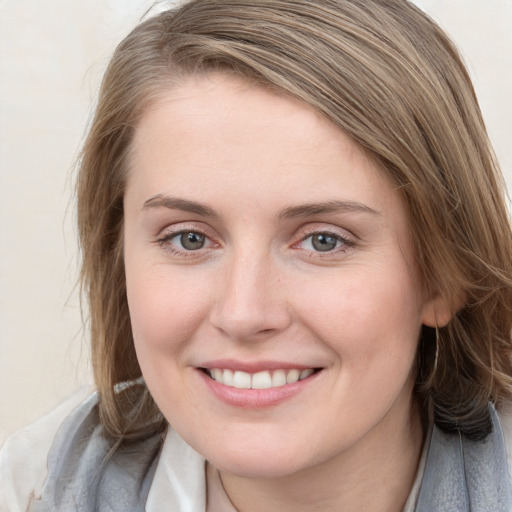 Joyful white young-adult female with medium  brown hair and blue eyes