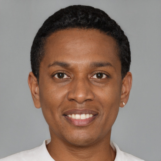Joyful black young-adult male with short  black hair and brown eyes