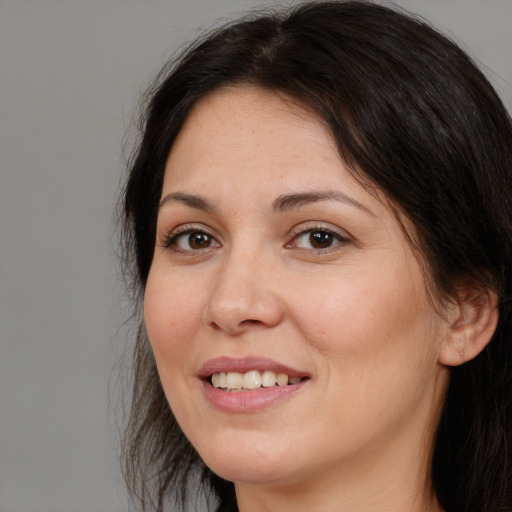 Joyful white adult female with long  brown hair and brown eyes