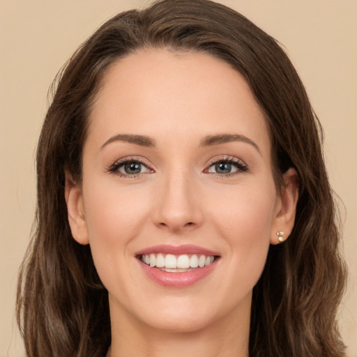 Joyful white young-adult female with long  brown hair and green eyes