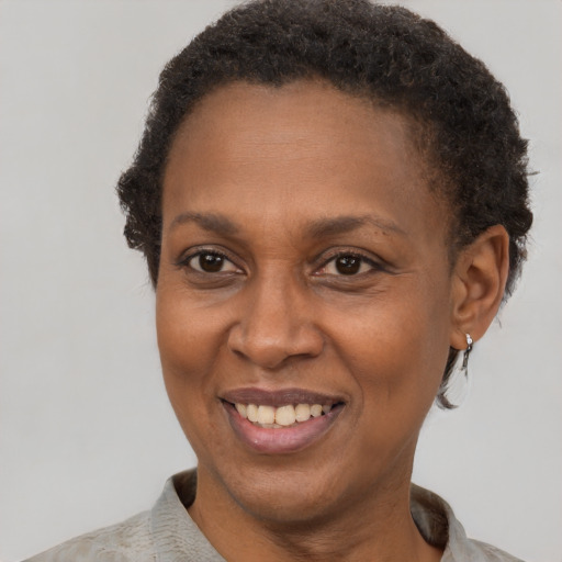 Joyful black adult female with short  brown hair and brown eyes