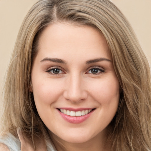 Joyful white young-adult female with long  brown hair and brown eyes