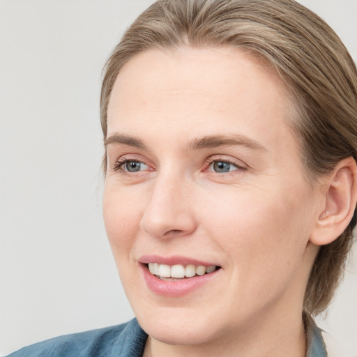 Joyful white young-adult female with medium  brown hair and blue eyes