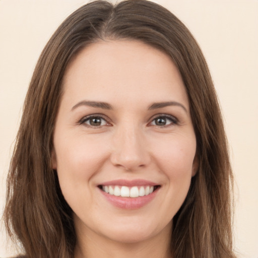 Joyful white young-adult female with long  brown hair and brown eyes