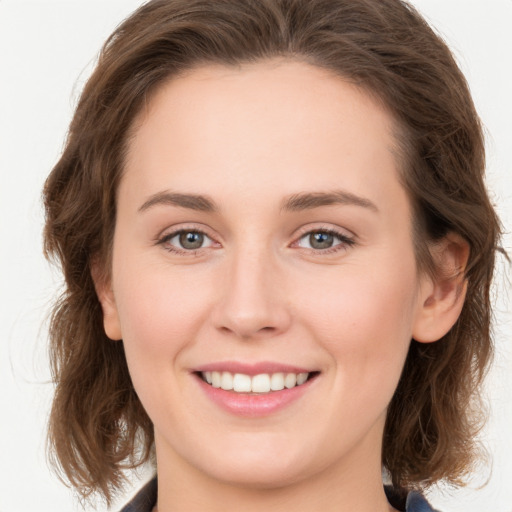 Joyful white young-adult female with long  brown hair and green eyes