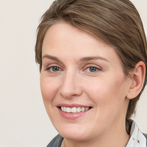 Joyful white young-adult female with medium  brown hair and grey eyes