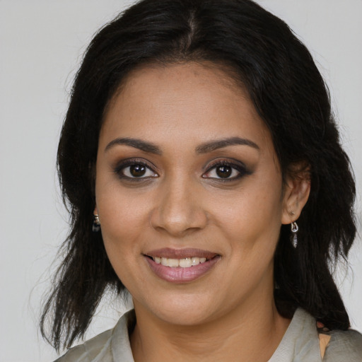 Joyful black young-adult female with long  brown hair and brown eyes
