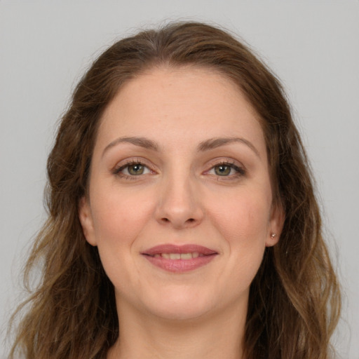 Joyful white young-adult female with long  brown hair and green eyes