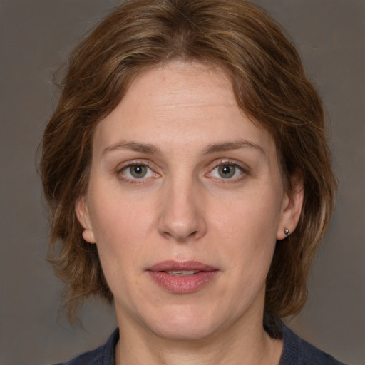 Joyful white adult female with medium  brown hair and grey eyes