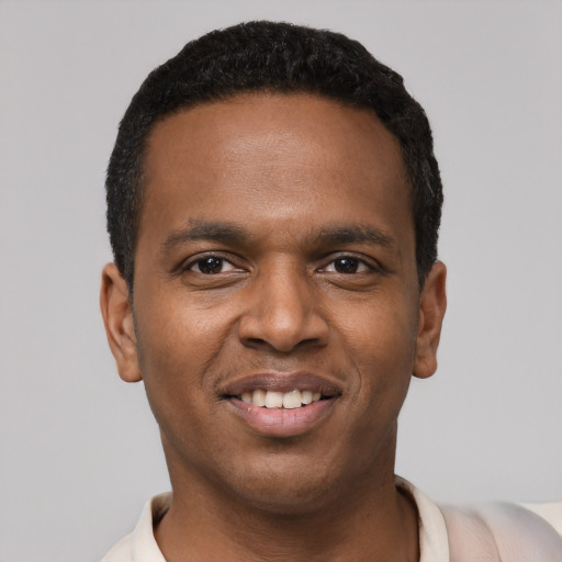Joyful black young-adult male with short  black hair and brown eyes