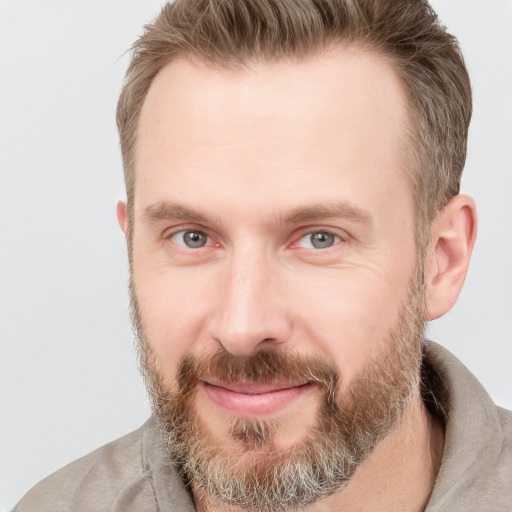 Joyful white adult male with short  brown hair and grey eyes