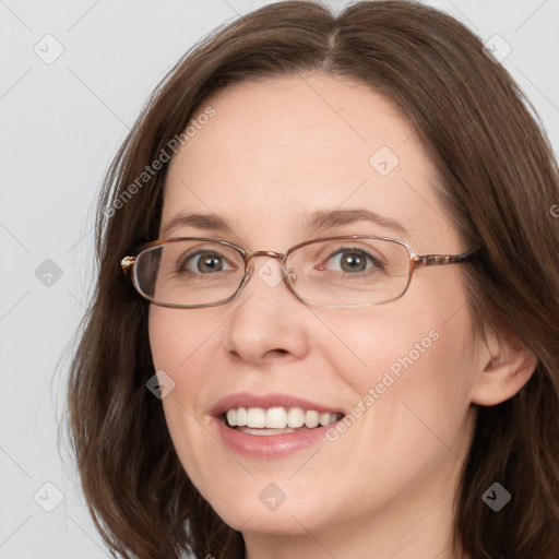 Joyful white adult female with long  brown hair and grey eyes