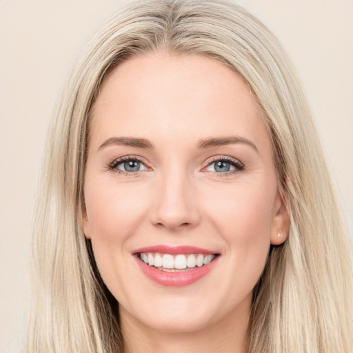 Joyful white young-adult female with long  brown hair and blue eyes