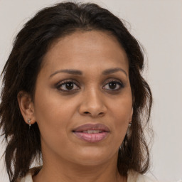 Joyful black adult female with long  brown hair and brown eyes