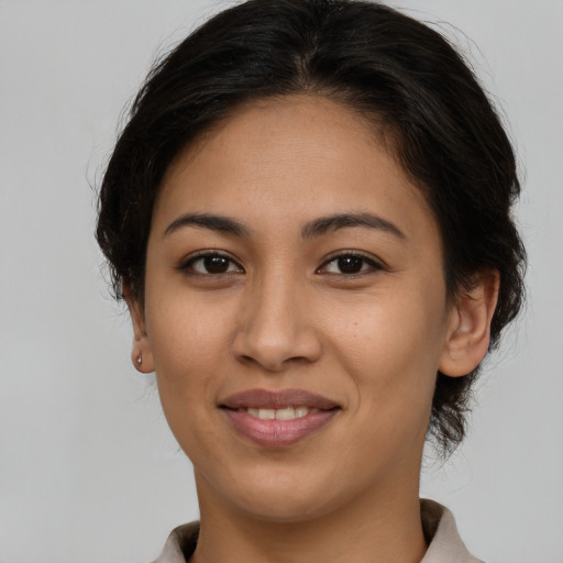 Joyful latino young-adult female with short  brown hair and brown eyes