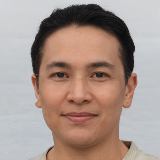 Joyful asian young-adult male with short  black hair and brown eyes