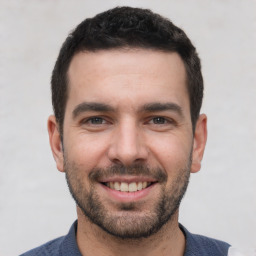 Joyful white young-adult male with short  black hair and brown eyes