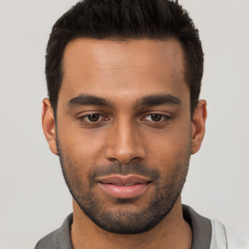 Joyful white young-adult male with short  black hair and brown eyes