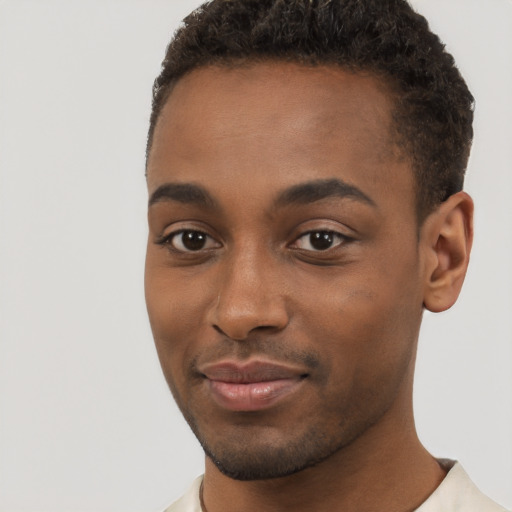 Joyful black young-adult male with short  brown hair and brown eyes