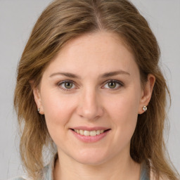 Joyful white young-adult female with medium  brown hair and green eyes