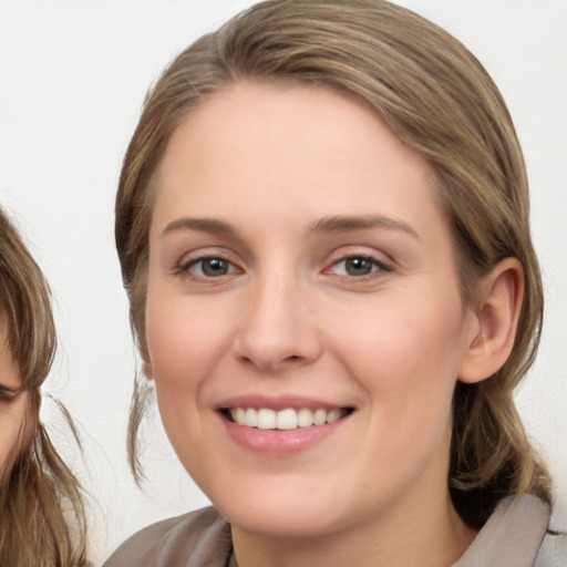 Joyful white young-adult female with medium  brown hair and blue eyes