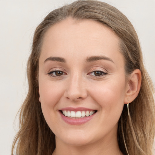 Joyful white young-adult female with long  brown hair and blue eyes