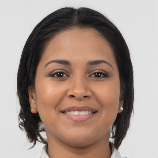 Joyful latino young-adult female with medium  brown hair and brown eyes
