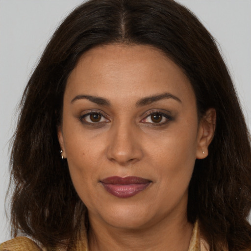 Joyful latino adult female with long  brown hair and brown eyes