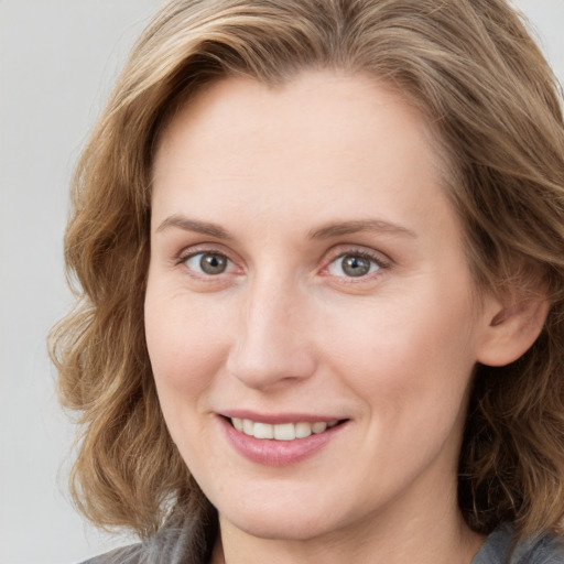 Joyful white young-adult female with medium  brown hair and blue eyes