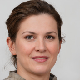 Joyful white adult female with medium  brown hair and grey eyes