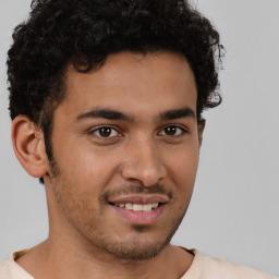 Joyful latino young-adult male with short  brown hair and brown eyes