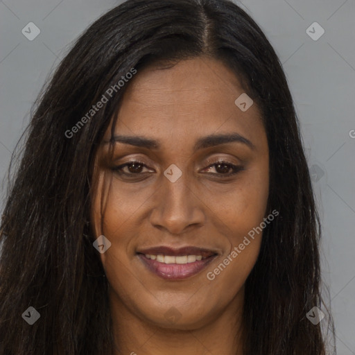 Joyful black young-adult female with long  brown hair and brown eyes