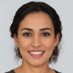 Joyful latino young-adult female with medium  brown hair and brown eyes