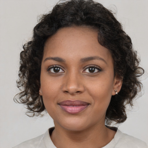 Joyful black young-adult female with medium  brown hair and brown eyes