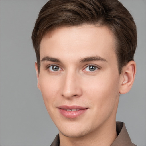 Joyful white young-adult male with short  brown hair and grey eyes