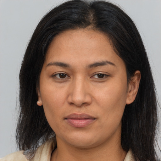 Joyful latino adult female with long  brown hair and brown eyes