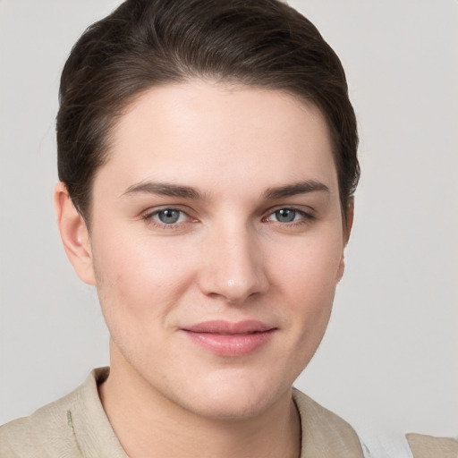 Joyful white young-adult female with short  brown hair and grey eyes