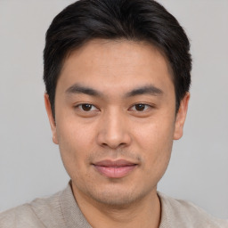 Joyful asian young-adult male with short  brown hair and brown eyes