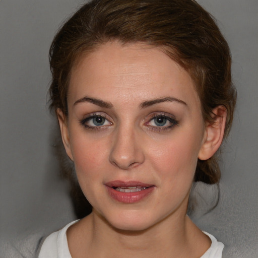 Joyful white young-adult female with medium  brown hair and blue eyes