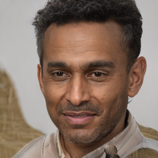 Joyful black adult male with short  brown hair and brown eyes